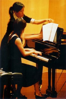 On tourne...
Accompagnement au piano d'un joueur de violoncelle, absent ici.

La jeune fille debout tourne les partitions...
